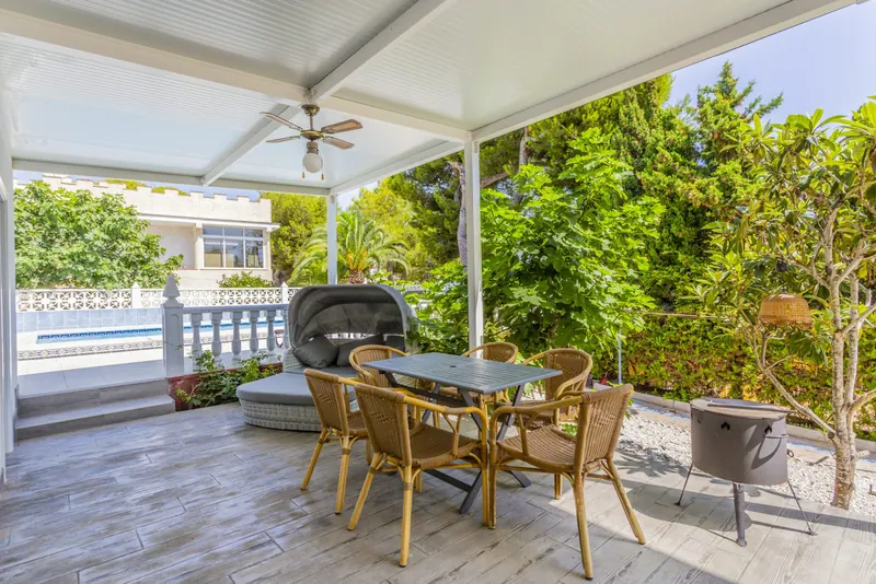 Überdachte Terrasse mit Loungemöbeln und Blick in den Garten