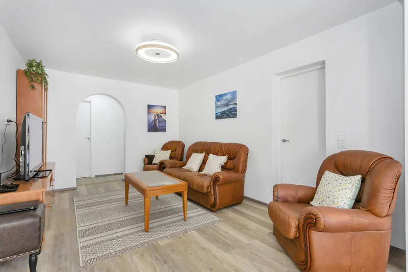 Helles Wohnzimmer mit Ledersofa und Fernseher
